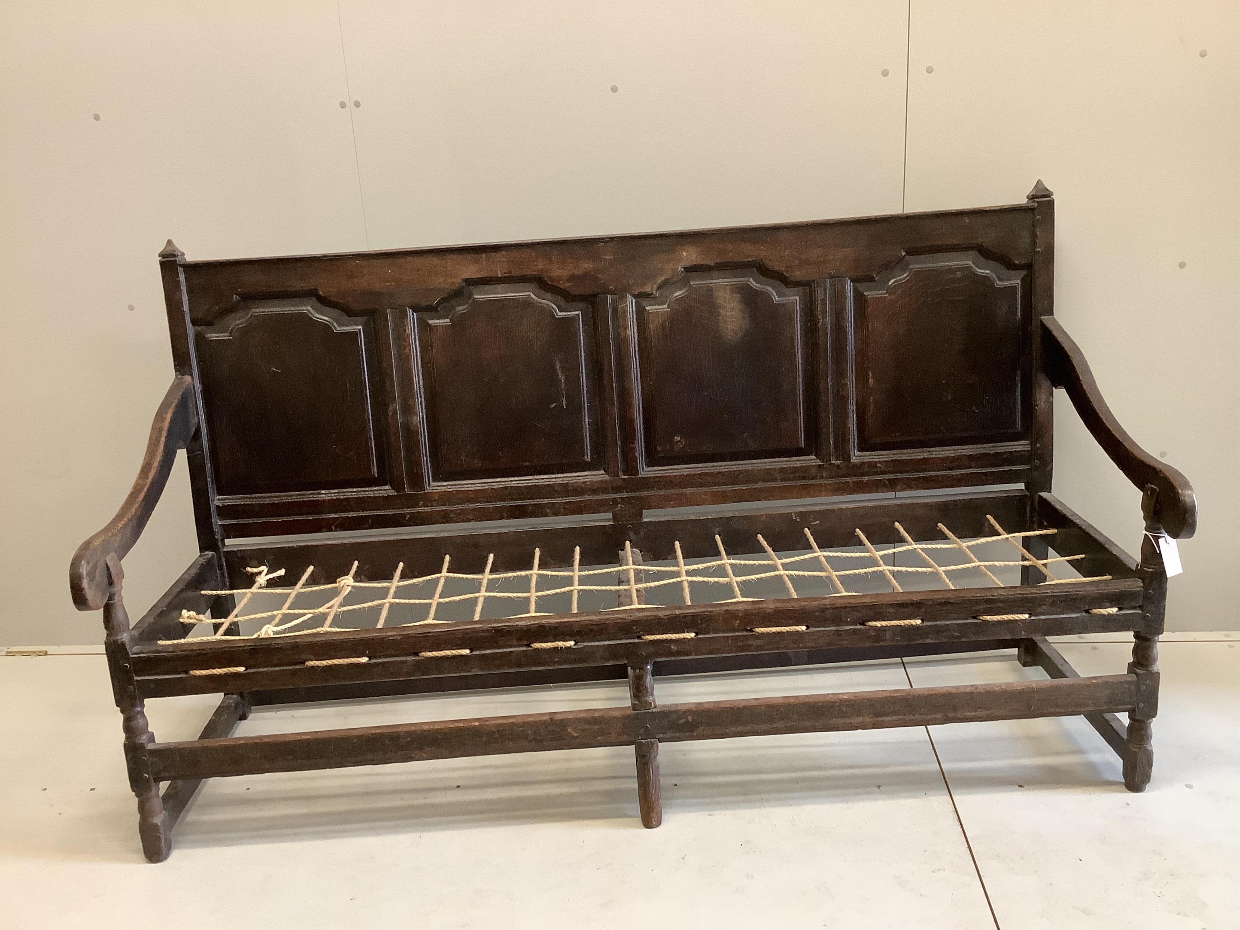 An 18th century panelled oak settle, width 188cm, depth 64cm, height 108cm